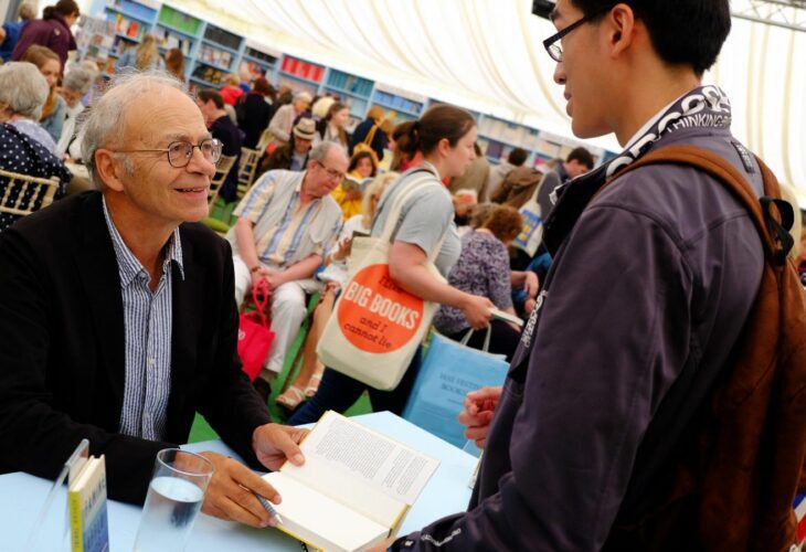 Peter Singer signs a book at a vegan festival