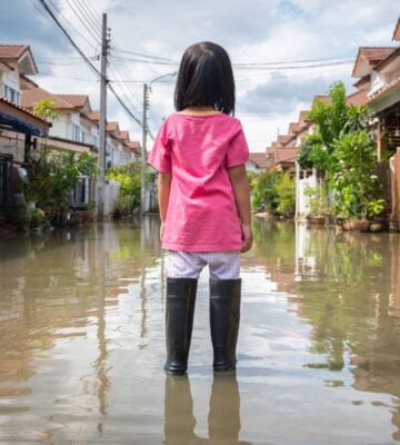 A girl in wellington boots standing in a flooded area