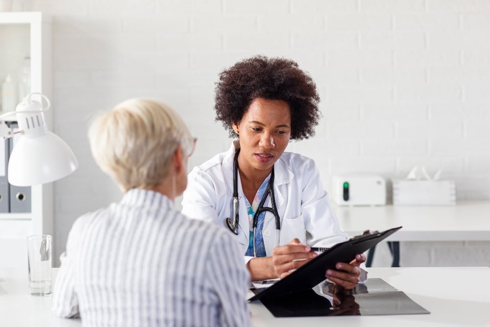 A doctor speaks with a patient at a hospital