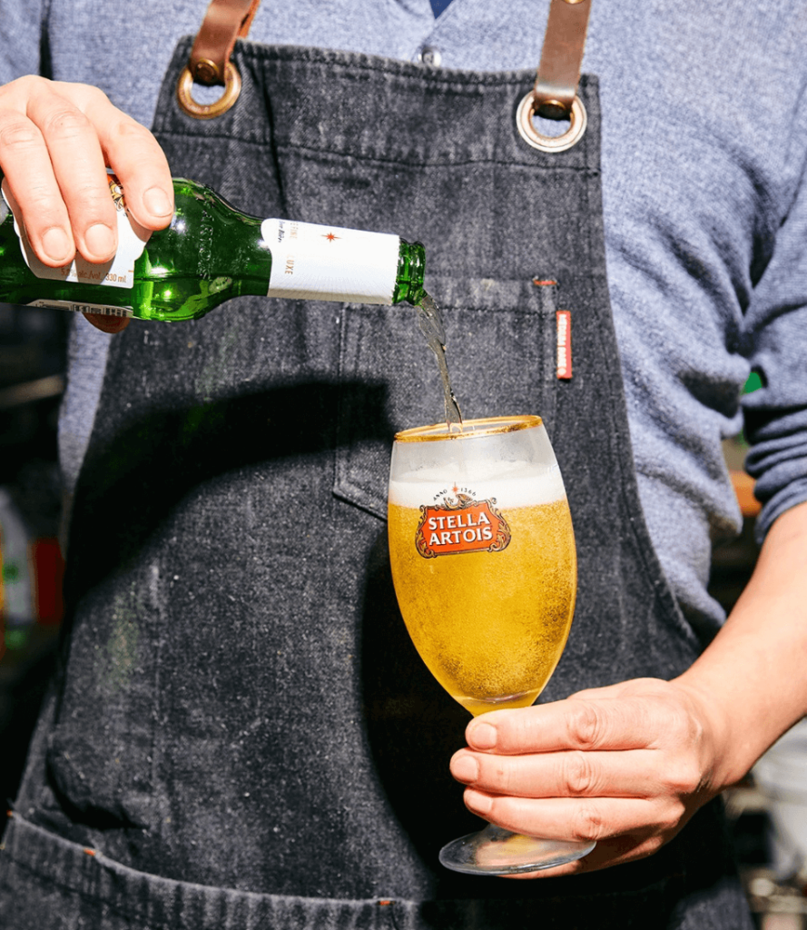 Vegan-friendly beer being poured into a glass reading Stella Artois
