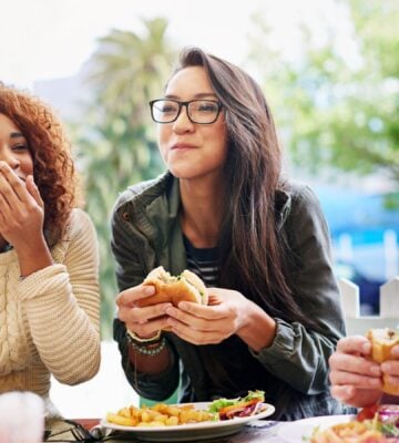 A group of three students eating food together