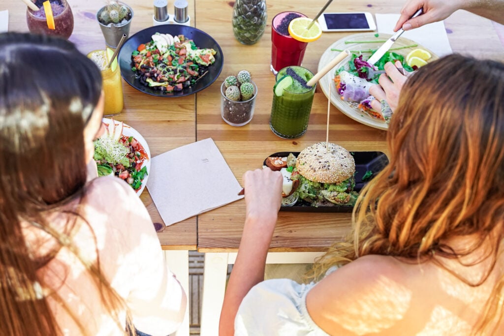 a group of students eating vegan food in a restaurant