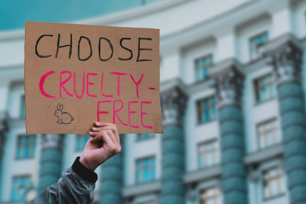 A person holding up a "choose cruelty-free" sign
