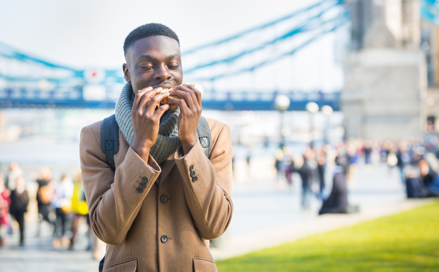 A man eating a sandwich by London Bridge - London has been named the most vegan-friendly city