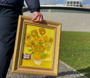 A member of the THIS team carrying the Sunflowers painting into Amsterdam's Van Gogh museum