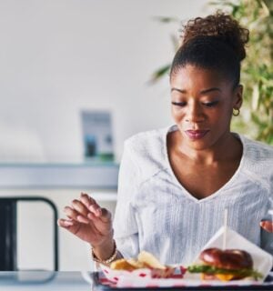 A woman wearing a white shirt sat at a table eating vegan food