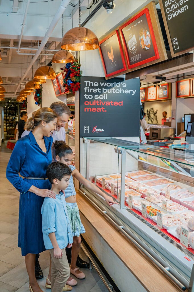 A family looking at cell-based meat in a butcher's shop in Singapore