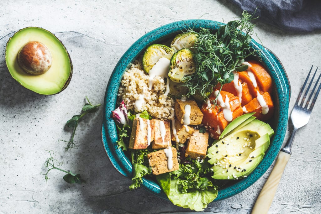 Vegan Buddha bowl with quinoa, tofu, avocado, sweet potato, brussels sprouts