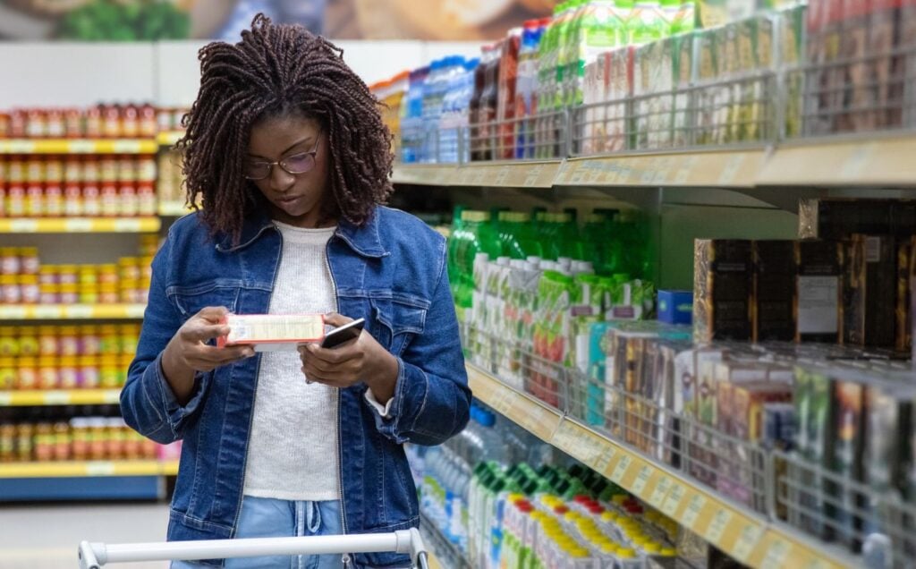 A person reading food labels at a supermarket