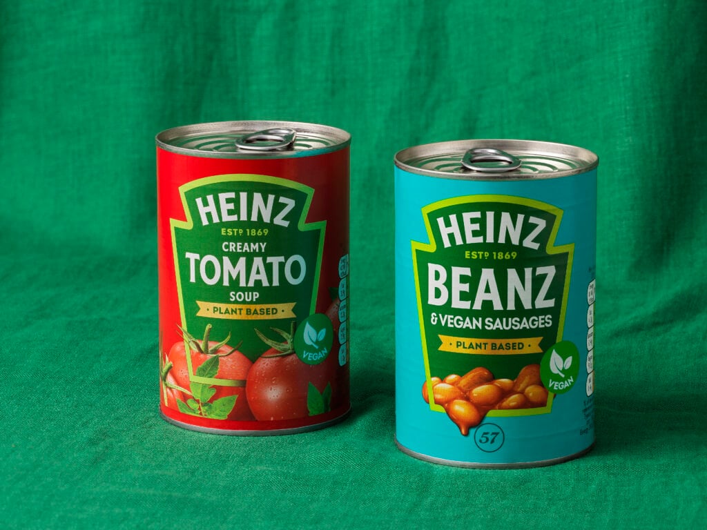 A can of Heinz vegan Cream Of Tomato soup besides a ban of vegan sausages and beans