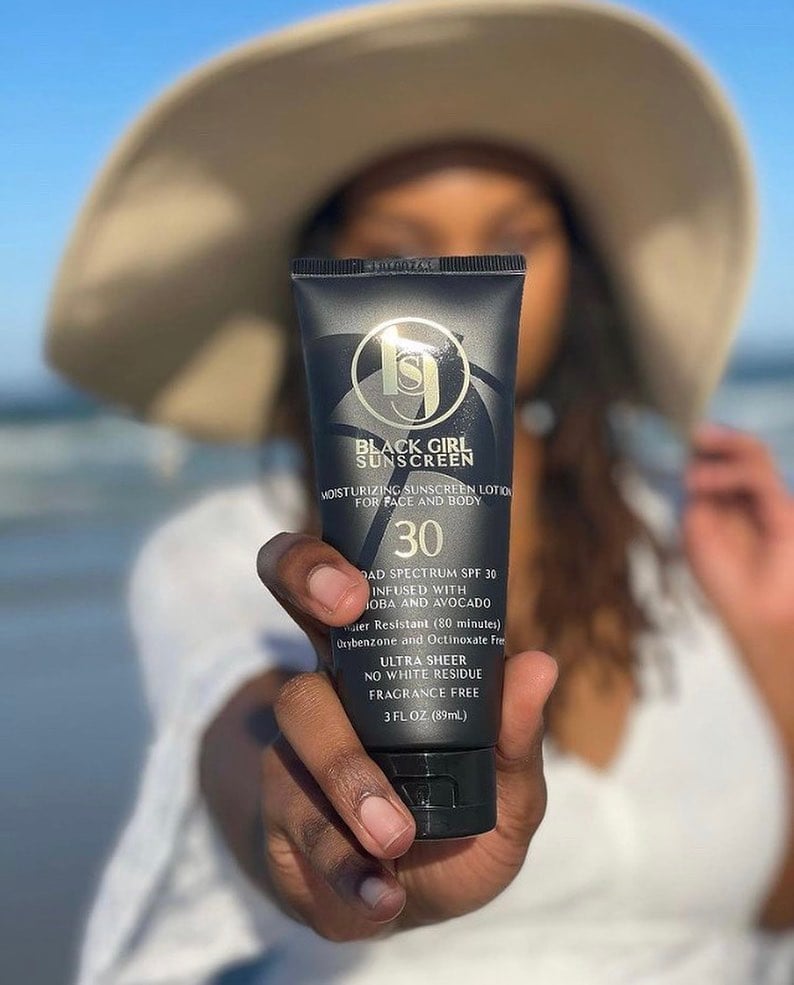 A woman holding a tube of vegan sunscreen by Black Girl Sunscreen