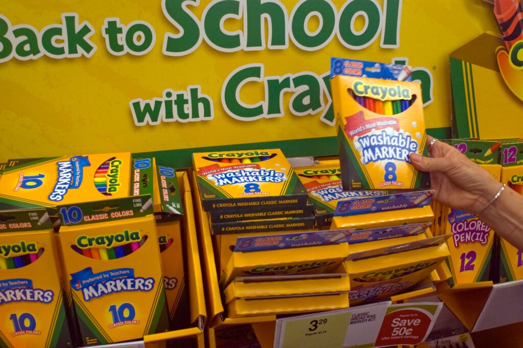 A person picking up Crayola Markers in a shop