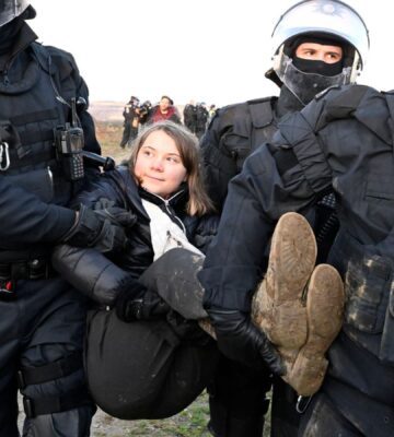 Vegan climate activist Greta Thunberg being carried away from a protest by the police