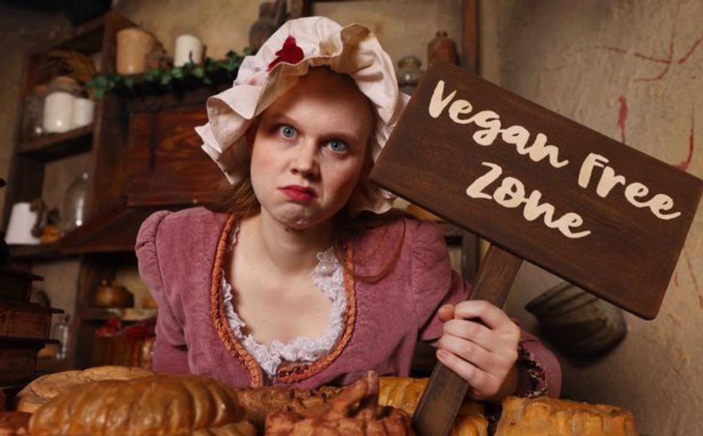 'Mrs Lovett' at London Dungeon holding up a "vegan free zone" sign