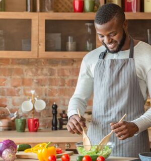 A man making a vegan salad in a kitchen