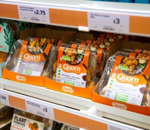 Supermarket shelves featuring vegan and vegetarian meat alternatives like Quorn