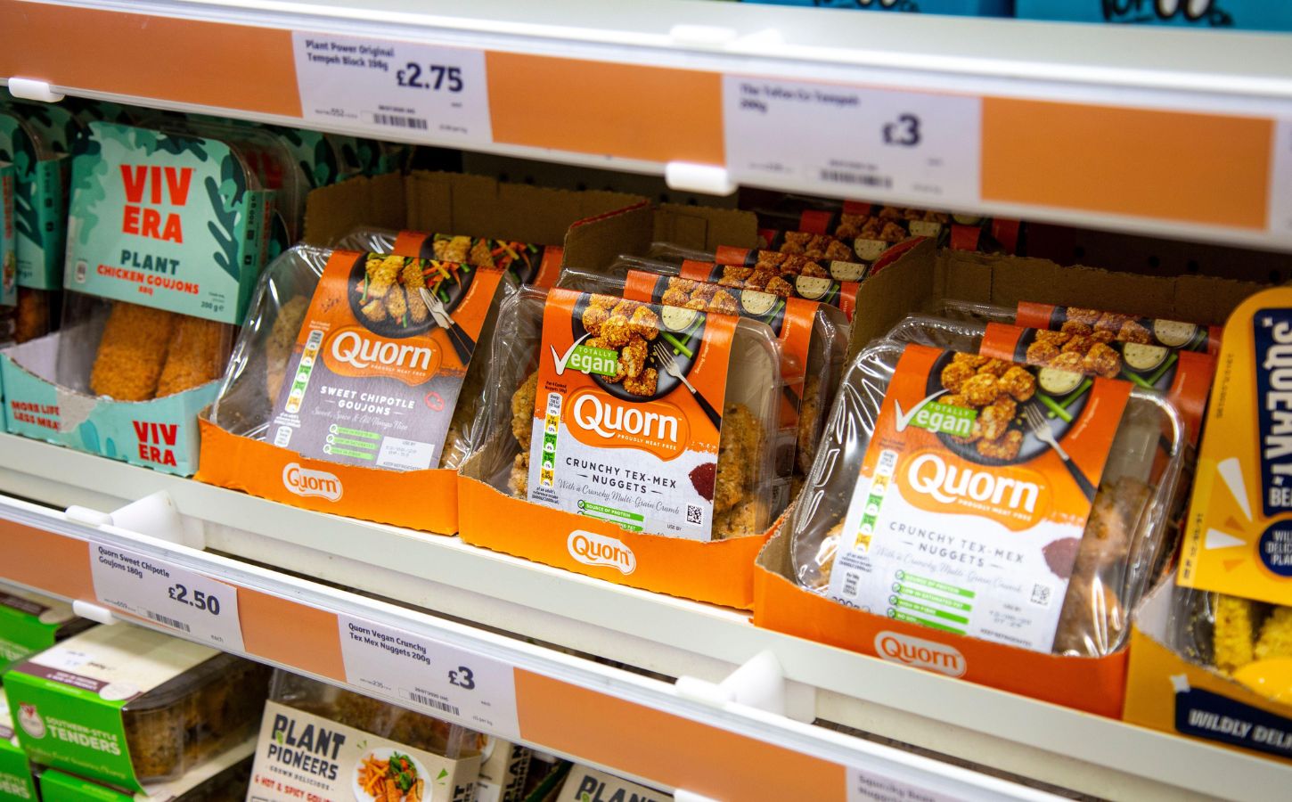Supermarket shelves featuring vegan and vegetarian meat alternatives like Quorn