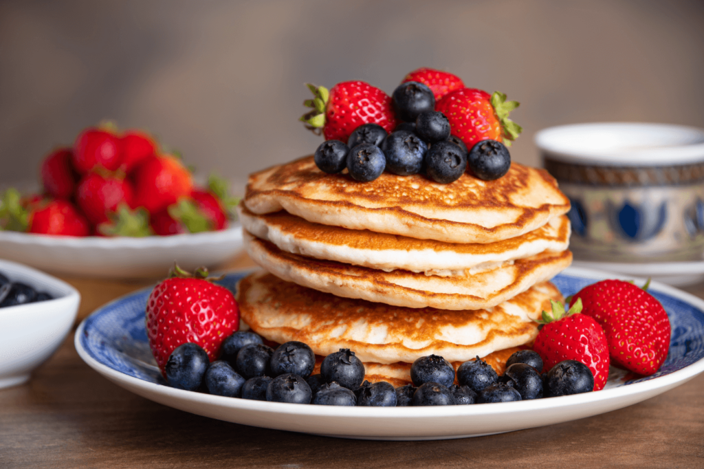 A plate of pancakes topped with nutritious berries, suitable for a healthy plant-based diet