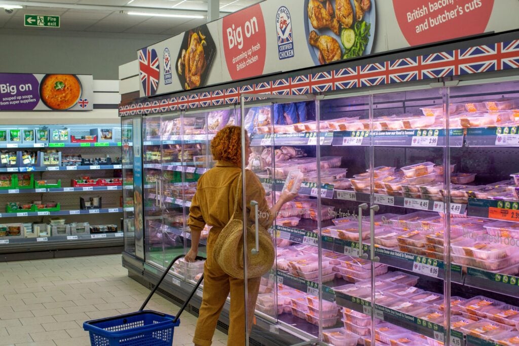A woman buying meat at budget supermarket Lidl in the UK