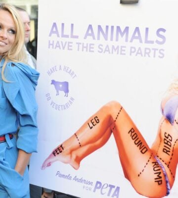 Pamela Anderson poses next to her PETA vegetarian campaign