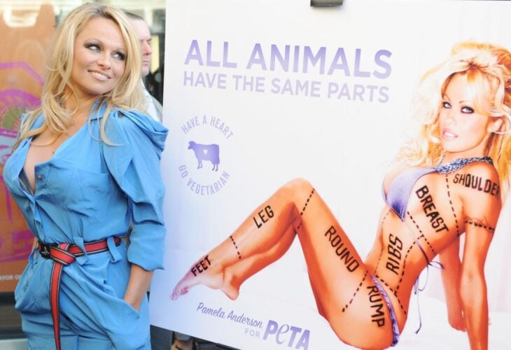 Pamela Anderson poses next to her PETA vegetarian campaign