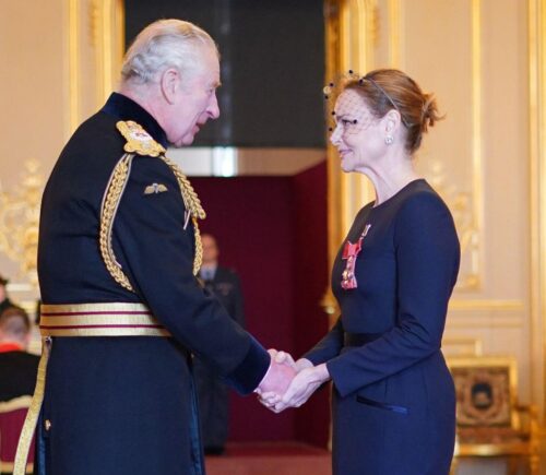 Vegetarian designer Stella McCartney shaking hands with King Charles after receiving her CBE