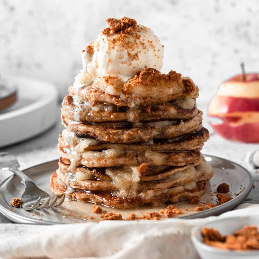 A stack of vegan apple-pie flavored pancakes, made from a breakfast and dessert recipe