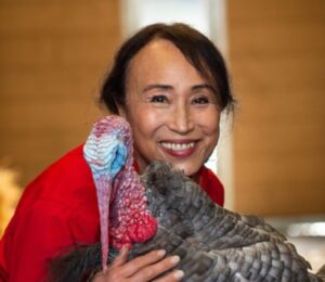 Vegan entrepreneur Miyoko Schinner, founder and former CEO of dairy-free cheese brand Miyoko's Creamery, pictured holding a turkey