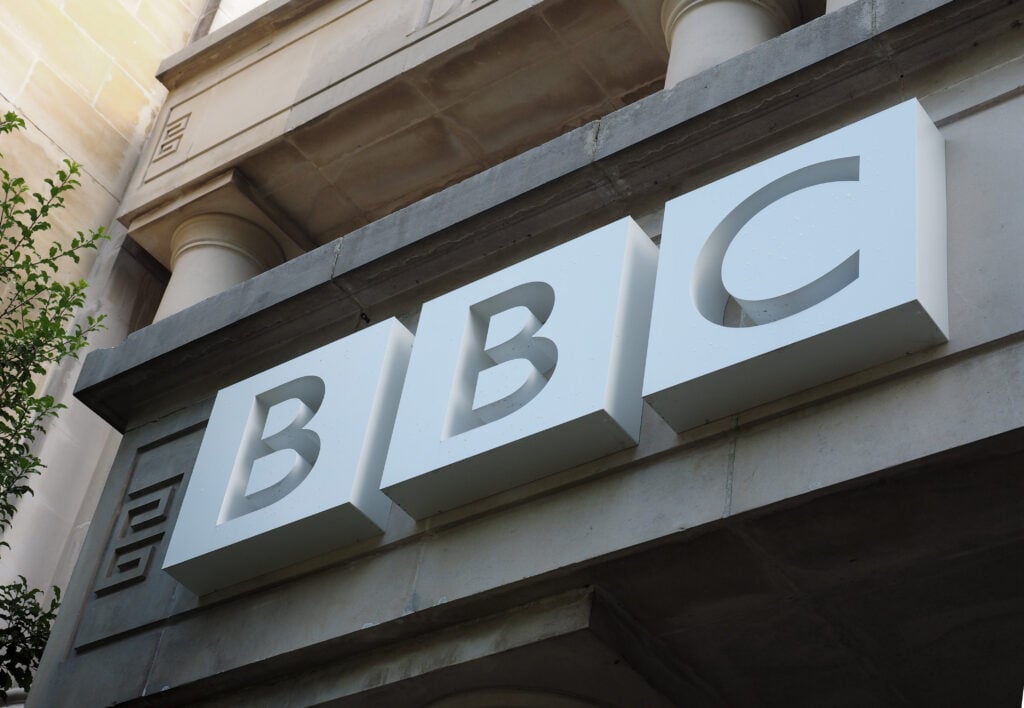 A white BBC sign outside the Bristol broadcasting house in the UK