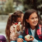 Children eating healthy plant-based food like fruit at a school