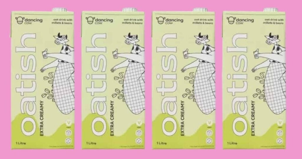 Four cartons of plain extra creamy vegan Oatish plant milk from Dancing Cow on a pink background