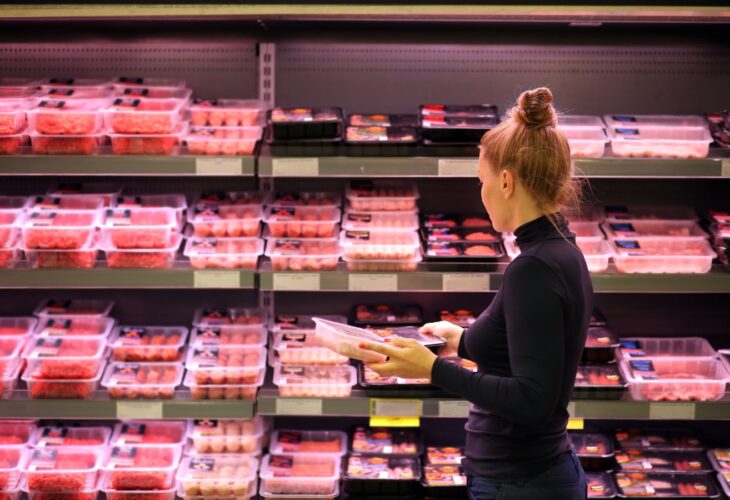 A woman shopping for raw meat in a supermarket