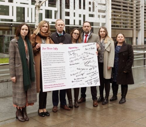 Animal rights campaigners holding a 'mother's day card' urging the uk government to ban pig farrowing crates