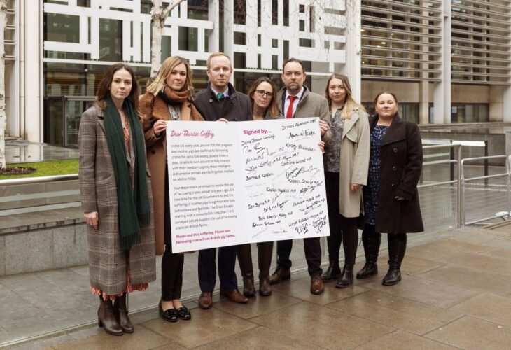 Animal rights campaigners holding a 'mother's day card' urging the uk government to ban pig farrowing crates
