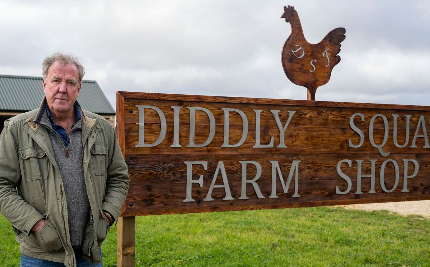 Jeremy Clarkson standing by a sign reading: "Diddly Squat Farm Shop"