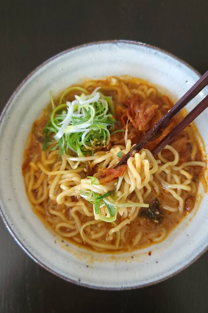 A bowl of freshly prepared vegan kimchi miso ramen served with chopsticks