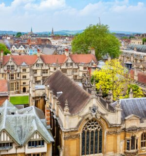 An aerial view of Oxford City, featuring old buildings and green trees