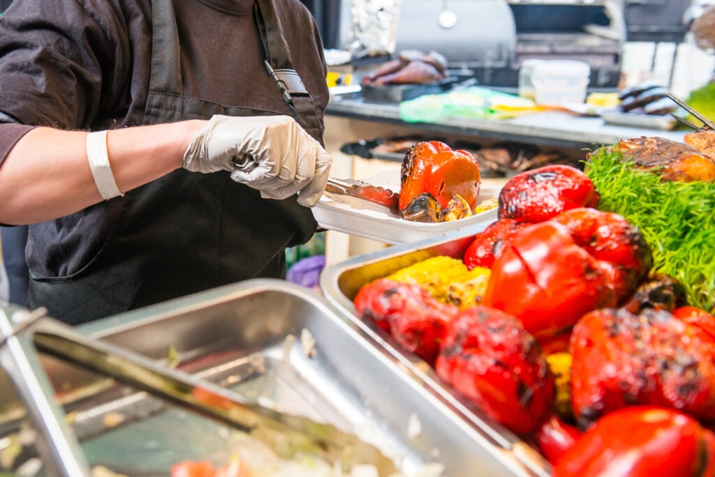 A person serving vegan meals at a council event