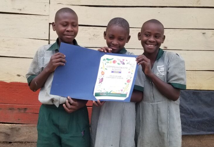 Three children from the Ugandan Atlas Community School in East Africa holding their TeachKind vegan award
