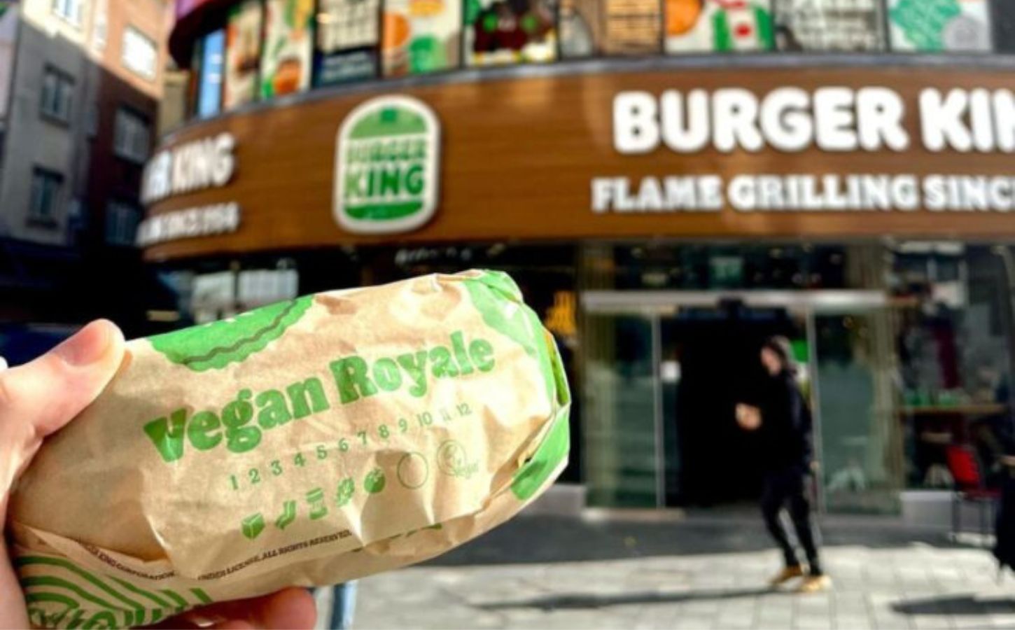A person holding a Vegan Royale outside a plant-based Burger King