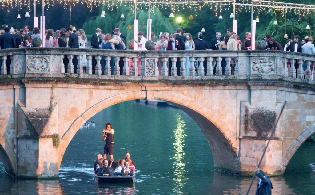 College students stand on a bridge while attending a ball at Cambridge University, which will be vegan this year