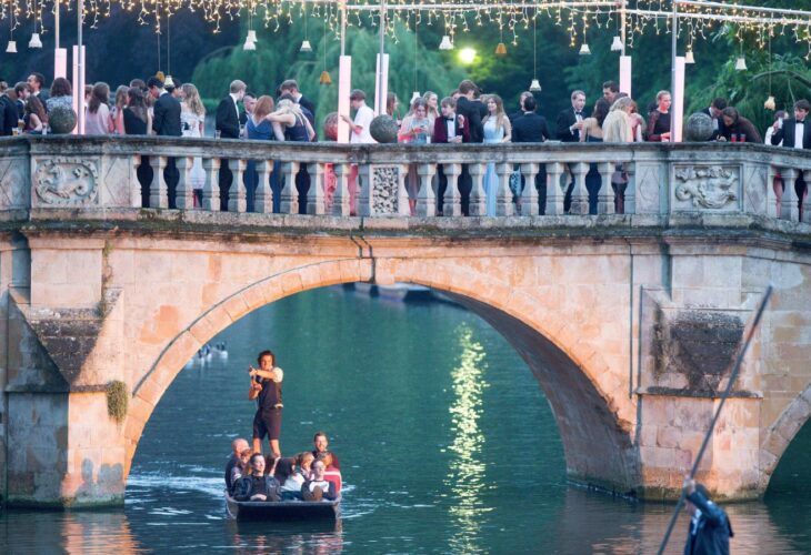 College students stand on a bridge while attending a ball at Cambridge University, which will be vegan this year