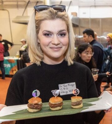 Dr Jess Krieger, founder of Ohayo Valley, holds a tray of three lab grown beef burgers
