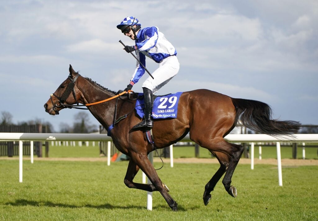 A jockey riding a race horse at the Grand National 2023