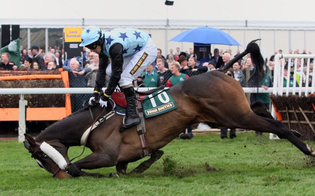 A horse falling over at the Grand National at Aintree, UK