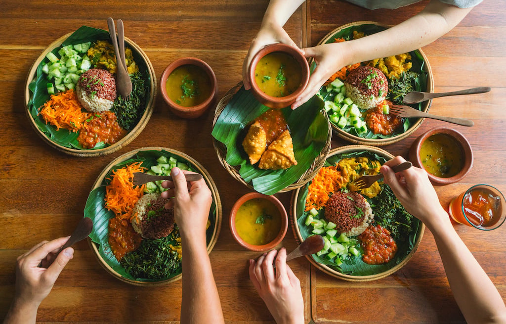 Vegetarian Indian food. several people eat Indian food at a common table together, a view from above.