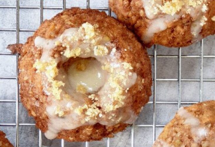 Small vegan nut-free carrot cakes with lemon drizzle and hemp heart praline cookies in a bundt tin and shot on a cooling rack