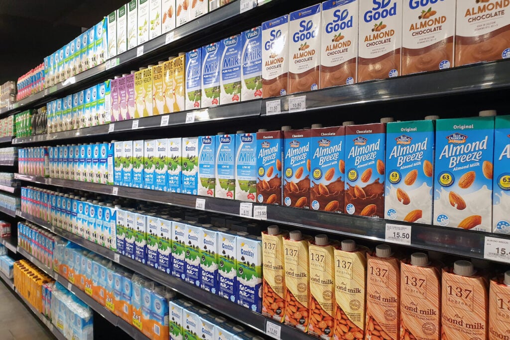 Supermarket shelves filled with vegan and dairy-free plant milk products