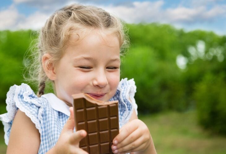 A young girl eating vegan chocolate