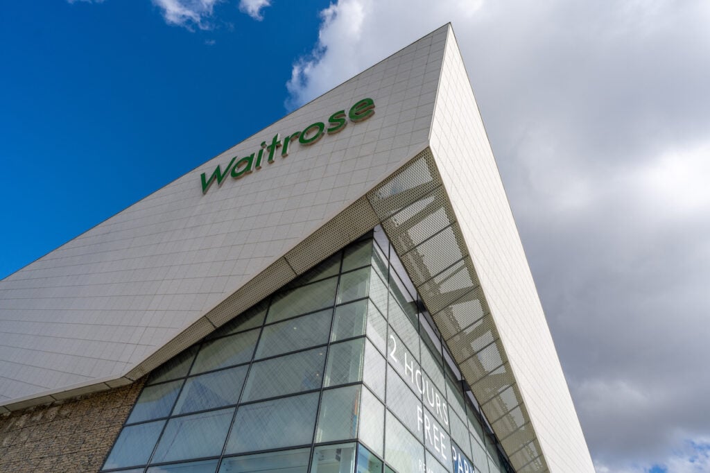 An artistic shot of a Waitrose building taken from below with the sky in shot